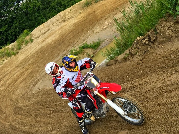 Motocross für Einsteiger aus Österreich: Trainer fährt in der Kurve hinter einer Anfängerin und zeigt die Linie